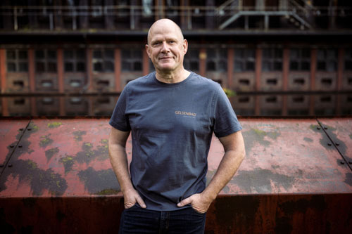 Zu sehen ist ein freundlicher Mitarbeiter der Firma Gelsenbad. Sein Blick zollt für seine Erfahrung und Reife.